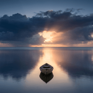 Calm ocean waters with warm morning sunlight breaking through parting storm clouds on the horizon